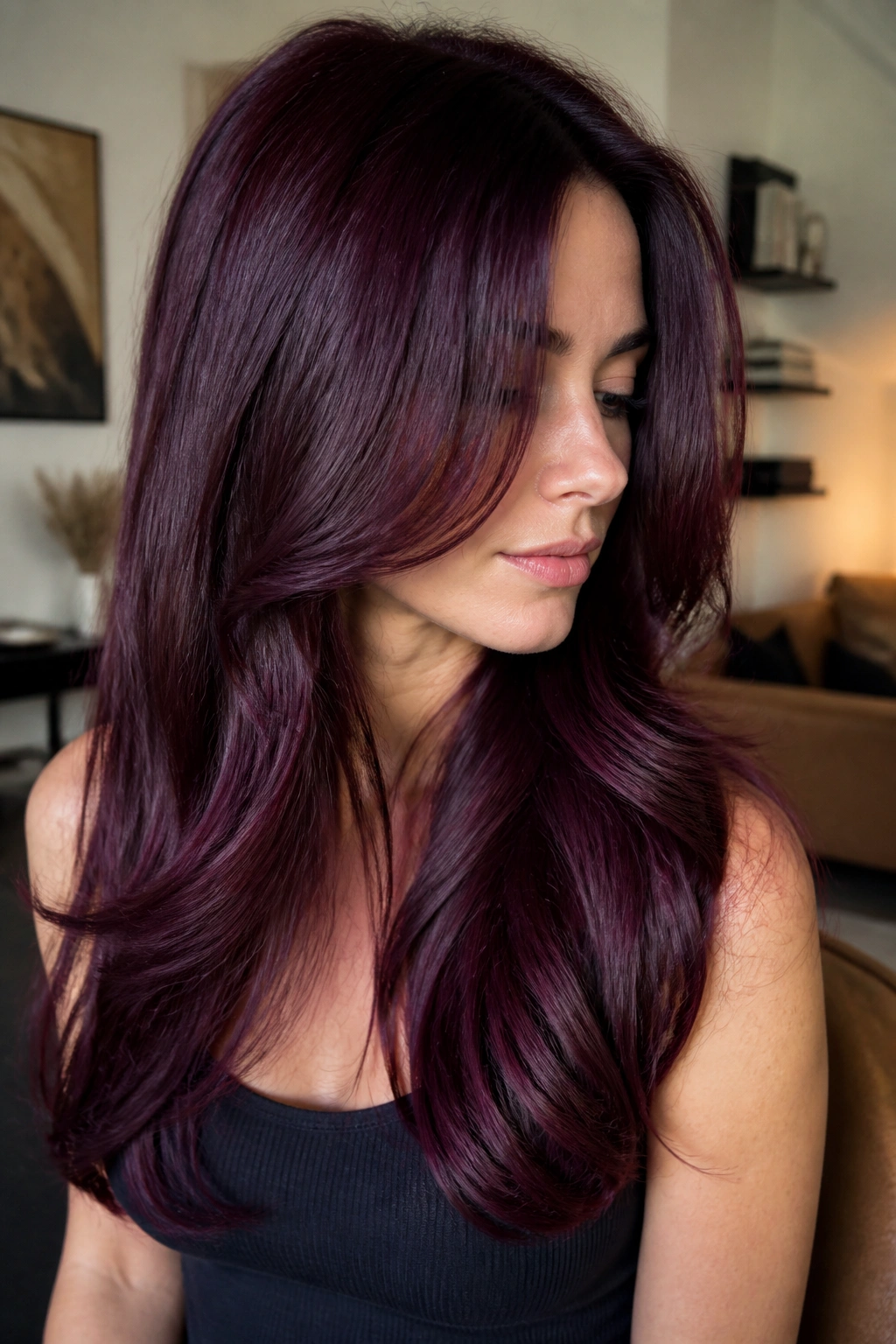 Close-up of long layered hair with violet burgundy gloss on a real person