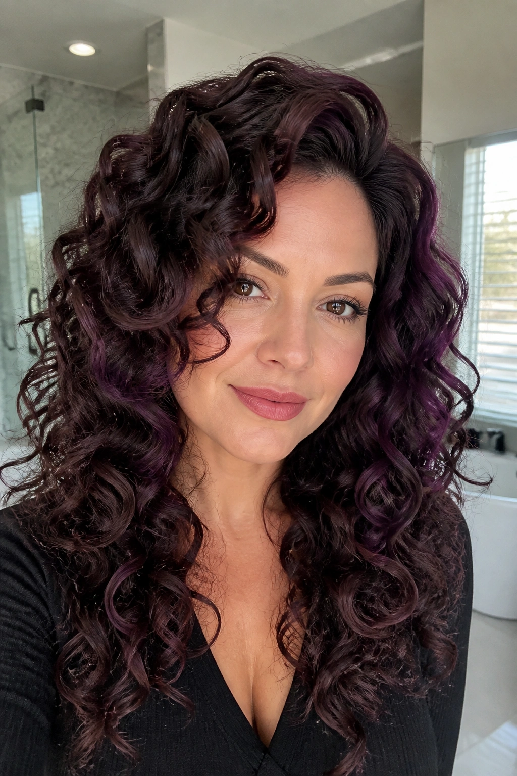Close-up of a real woman with violet glaze on curly hair emphasizing curls