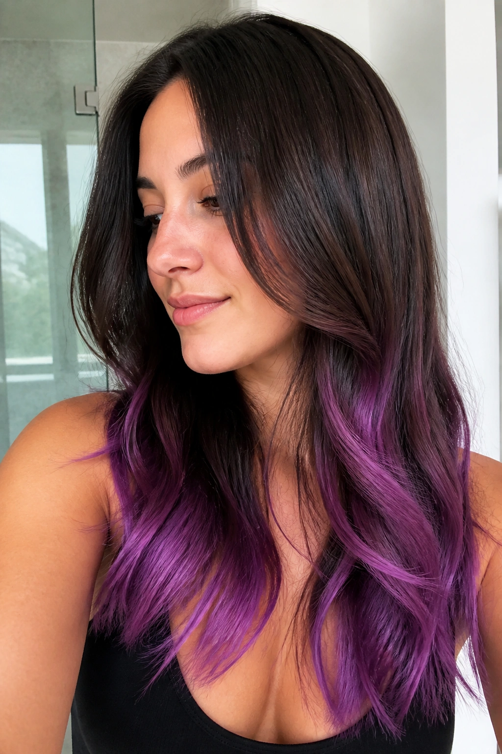 Close-up of brunette hair with violet ombré ends in natural light.