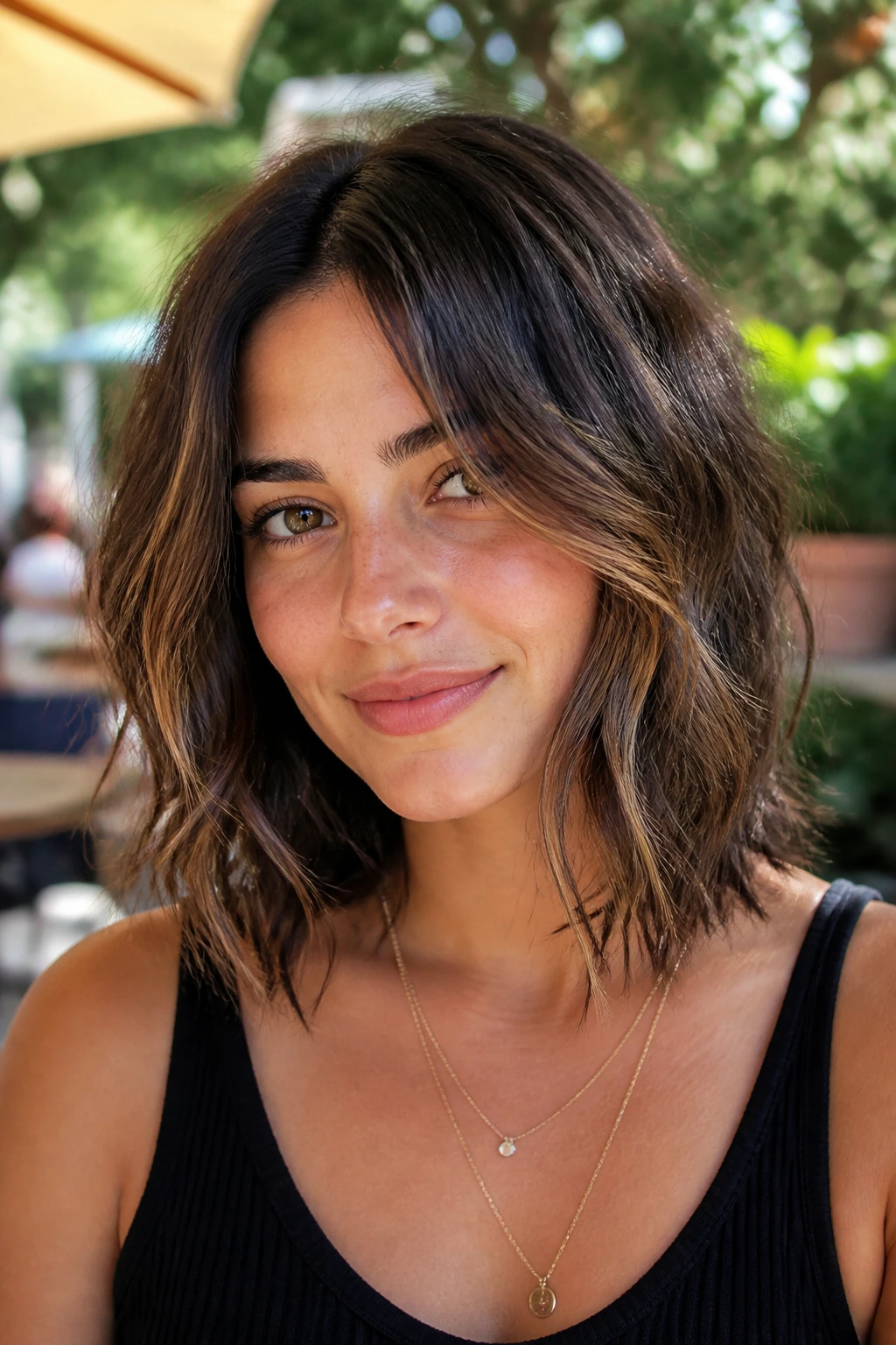 Close-up of a real woman with a wavy lob and piecey ends in natural light.