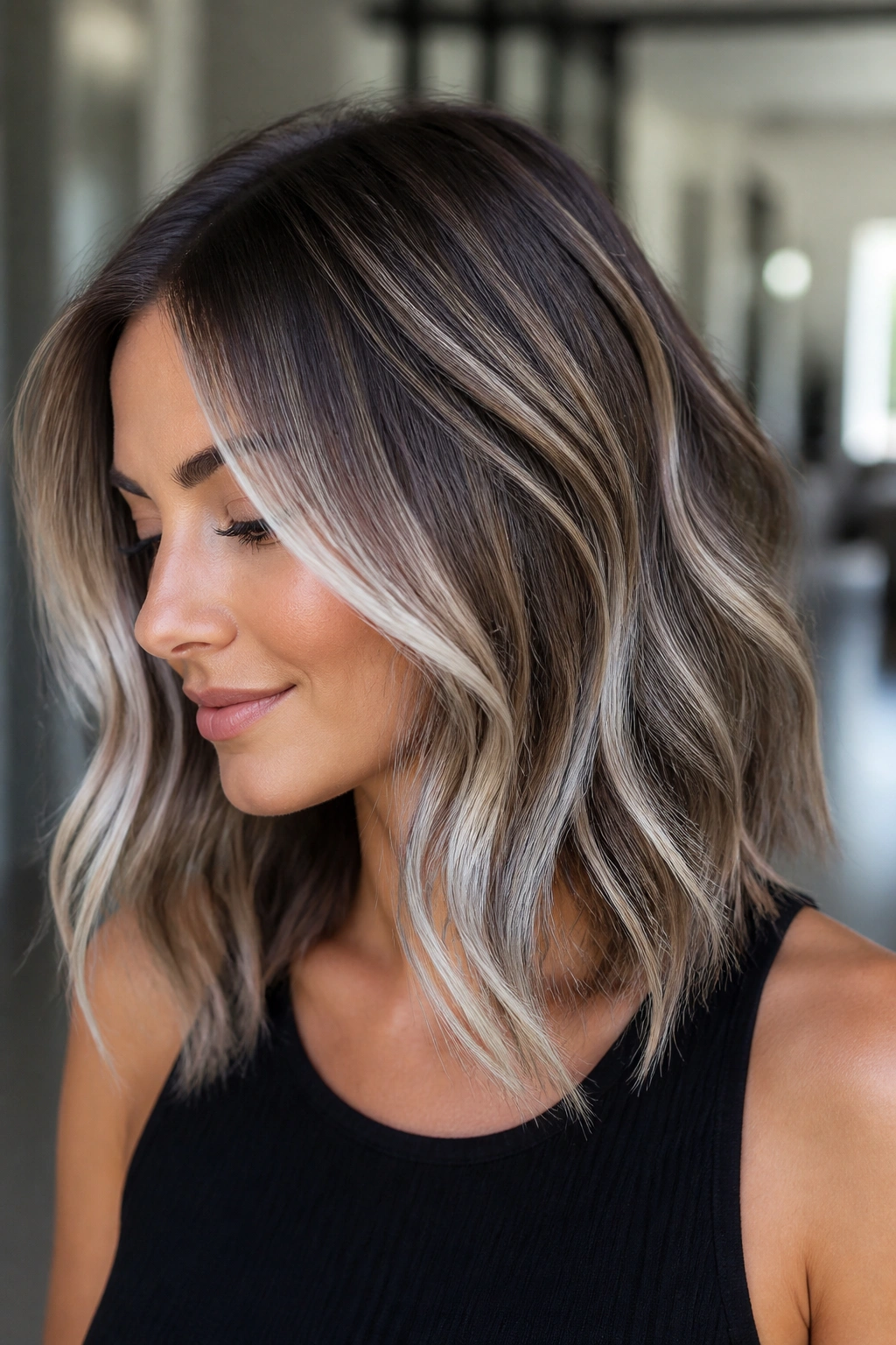 Real woman with white balayage on brunette lob, shoulder-length hair