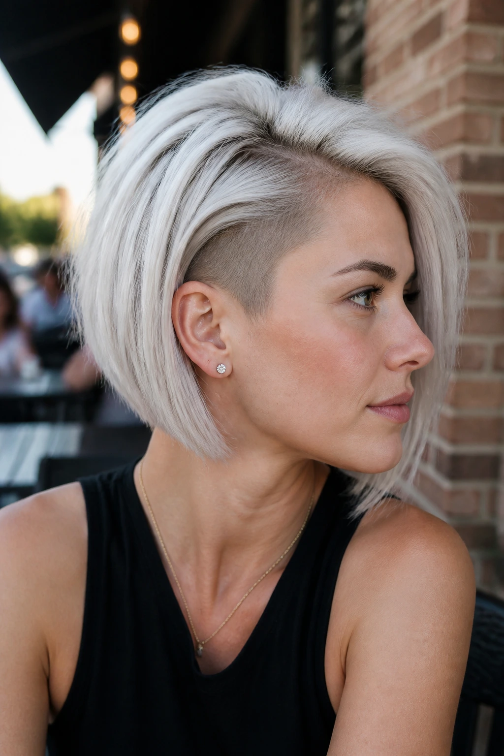 Close-up of a real woman showing a subtle undercut at the crown of a white bob.